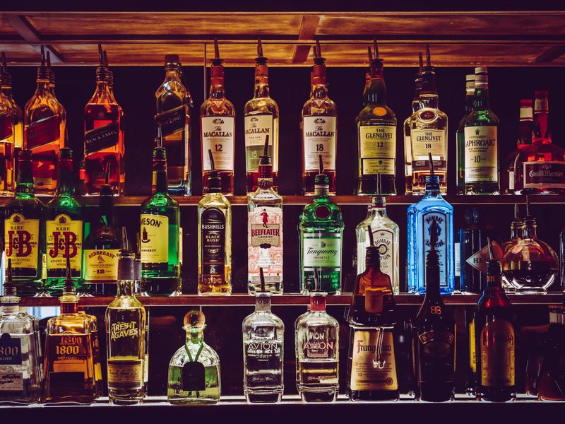 Assorted spirit bottles displayed on a bar shelf